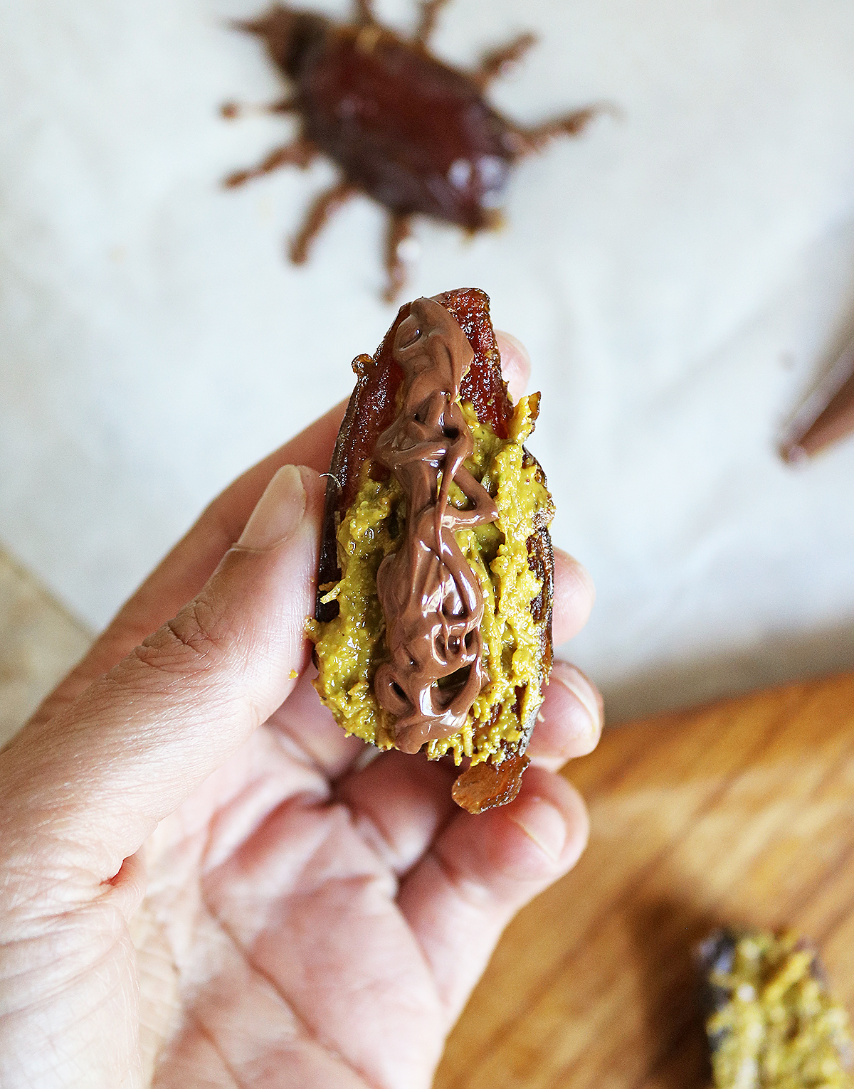 Adding chocolate to the back of the stuffed dates