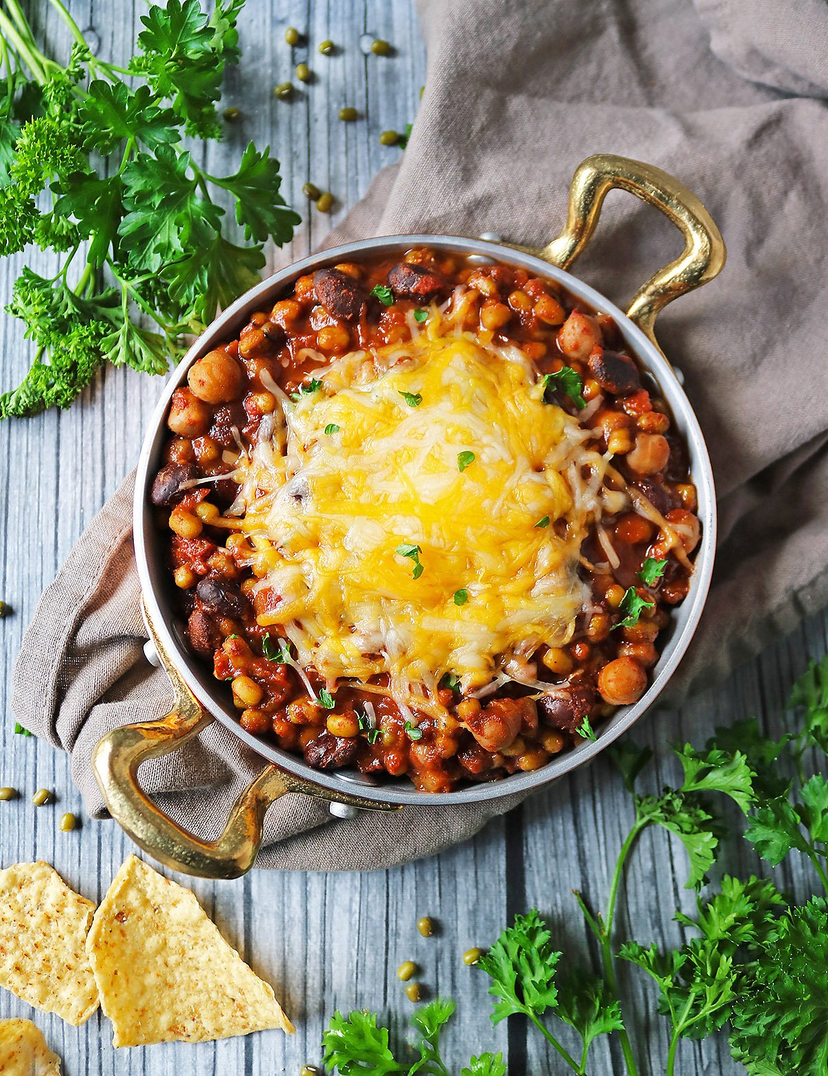 Easy Vegetarian Three Bean Stew with cheese and nachos.