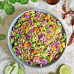 Overhead view of Moong Bean Quinoa and Vegetables in a bowl with cucumber and limes near.