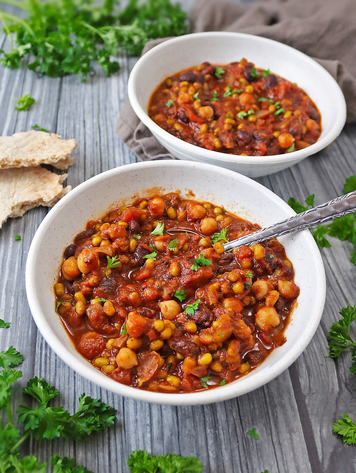 a bowl of Slow Cooker Three Bean Stew with parsley.