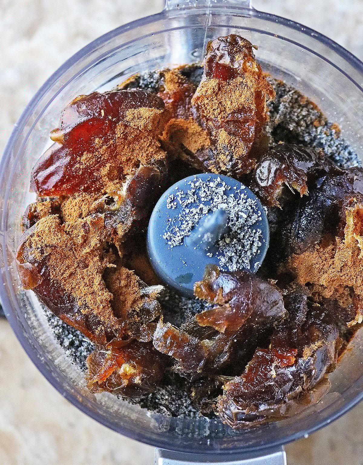 Adding black sesame powder, dates, cinnamon, vanilla to food processor