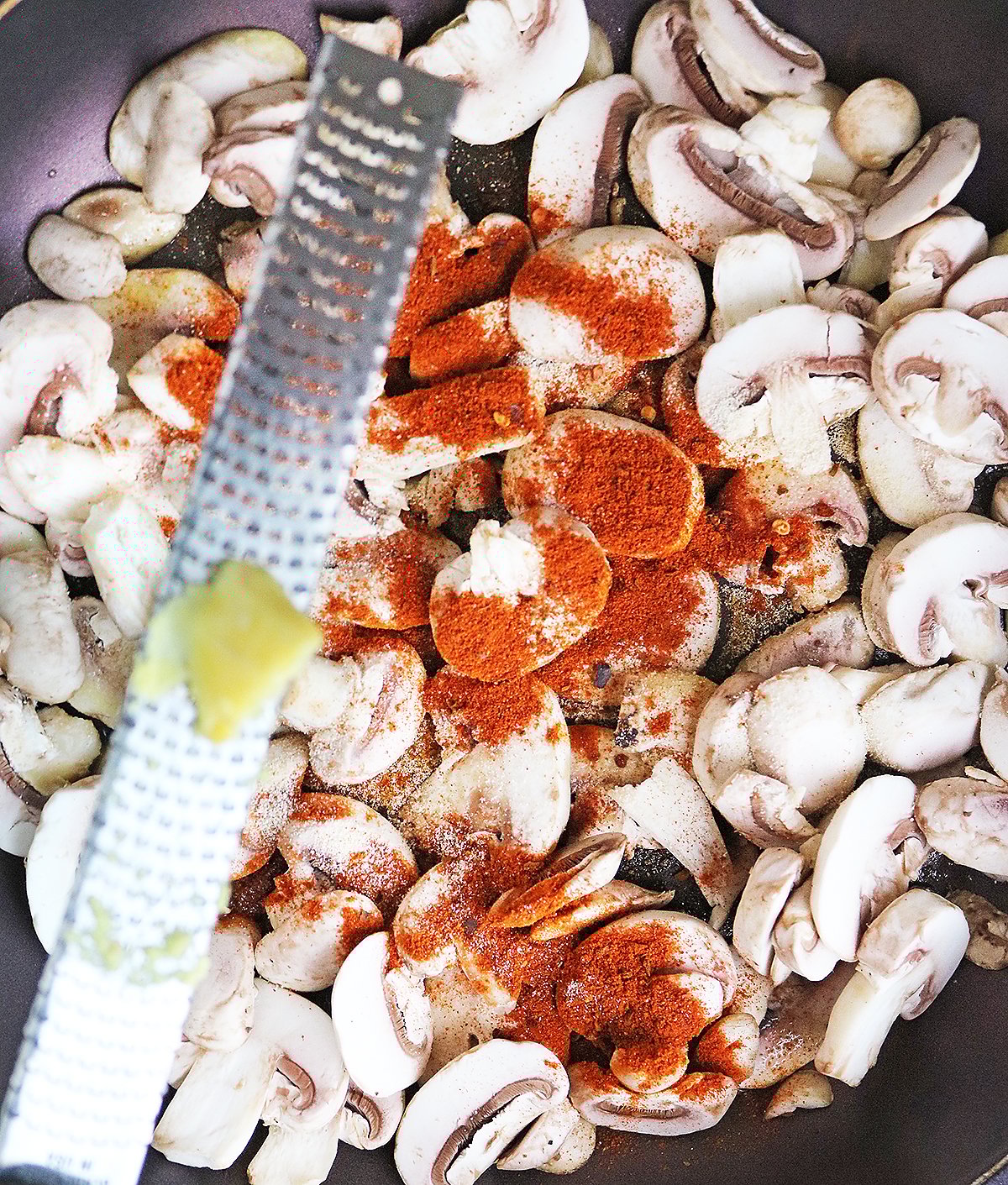 Grating ginger into the spice mushrooms