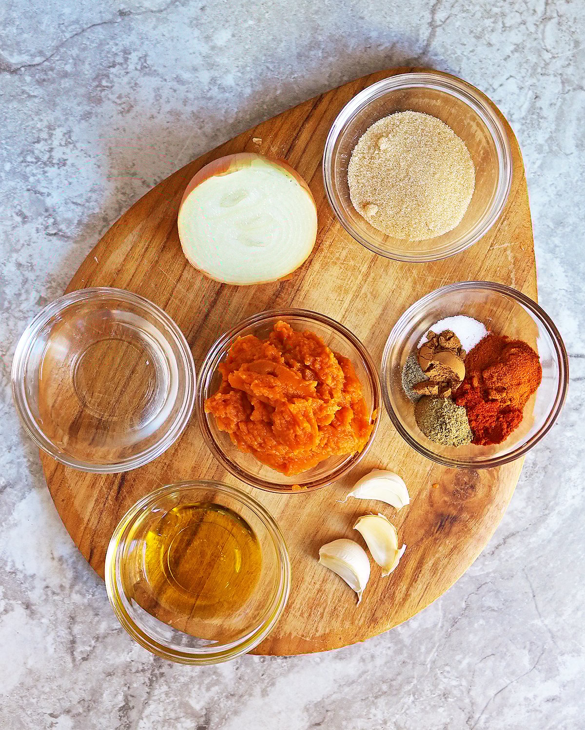 12 Ingredients needed to make this delicious healthy pumpkin chutney on a brown platter.