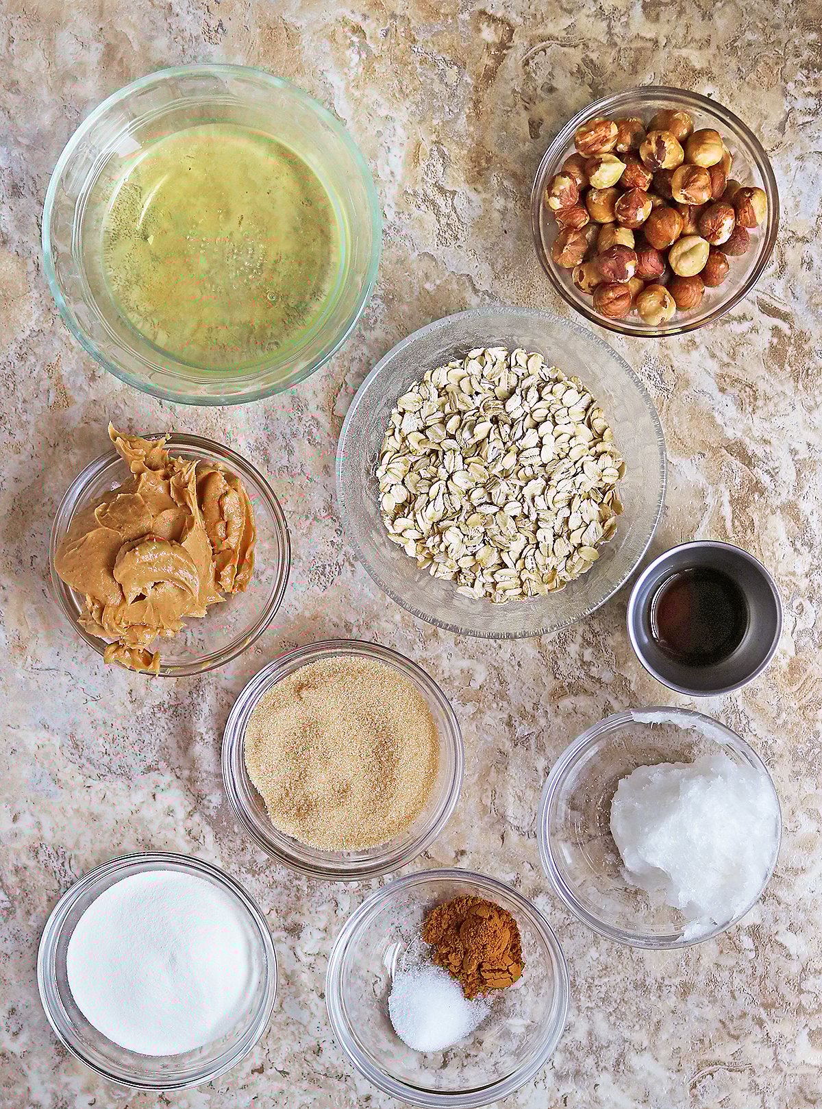 10 ingredients to make copycat nature valley bar granola SET ON A BROWN MARBLE BACKGROUND.