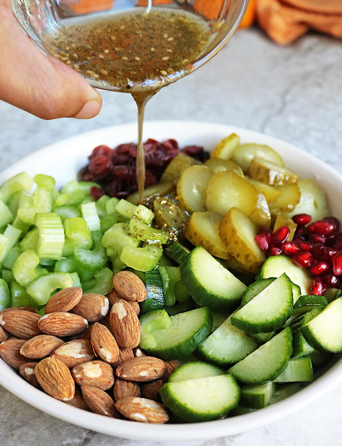 Pouring an easy vinaigrette onto pickle salad.