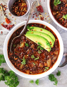 black lentils cooked in a spiced tomato broth to make a delicious black lentil soup.