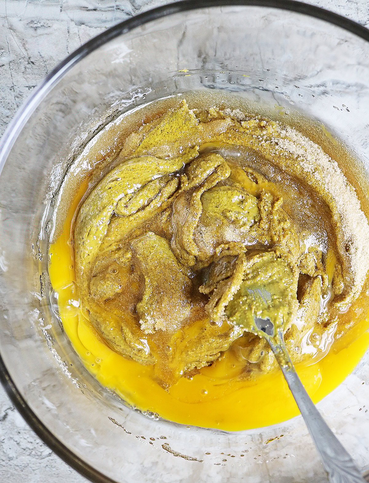 mixing together egg pistachio butter and sweetener