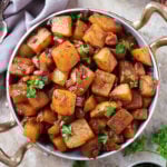 Pan Roasted Turnips with Harissa in a golden skillet with parsley on the side.