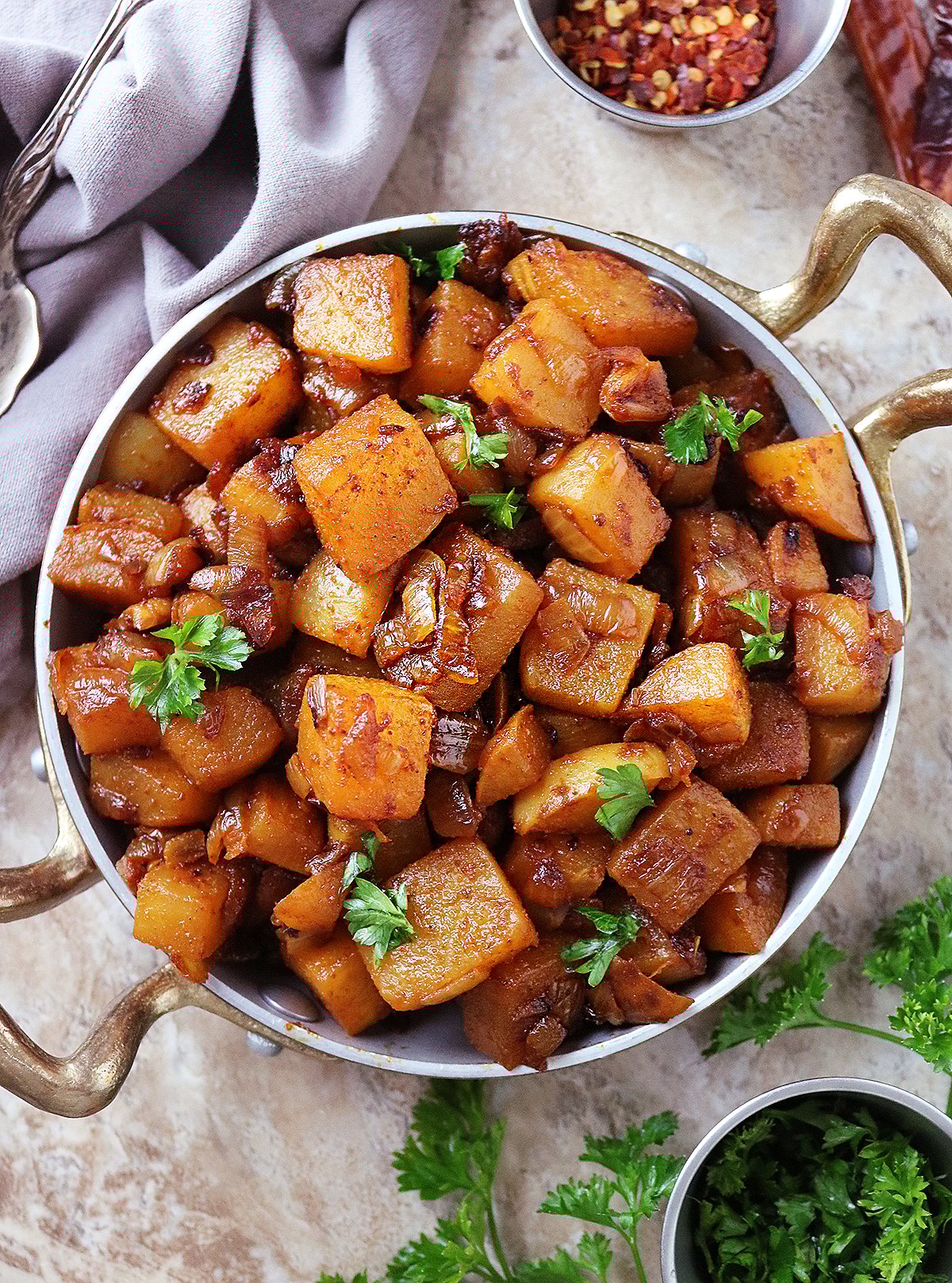 Pan Roasted Turnips with Harissa in a golden skillet with parsley on the side.