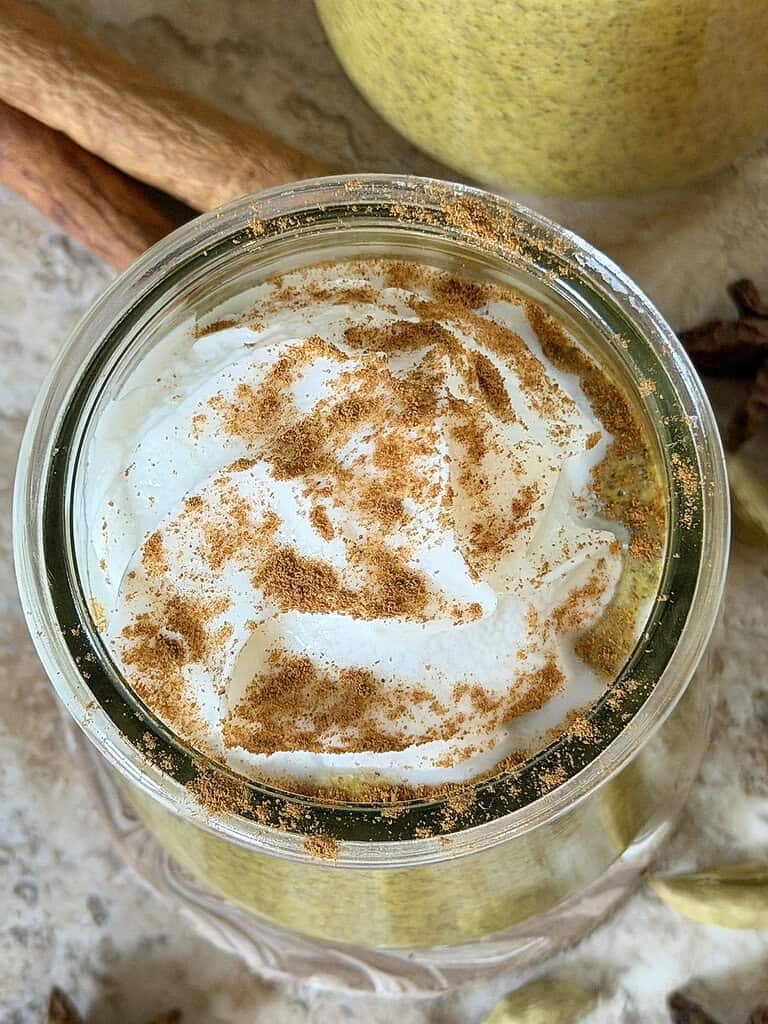 Instant Golden Milk Chia Pudding with coconut whipped topping and cinnamon