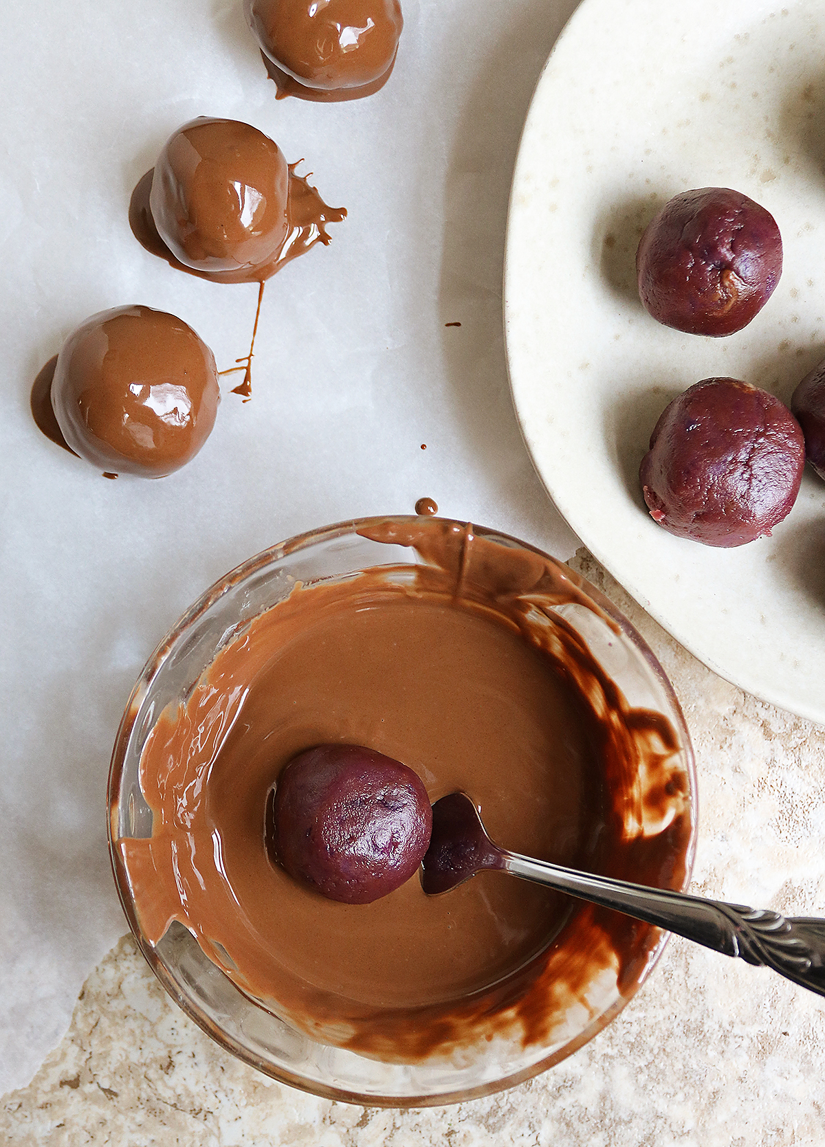 coating the sweet potato PB chocolate balls in chocolate