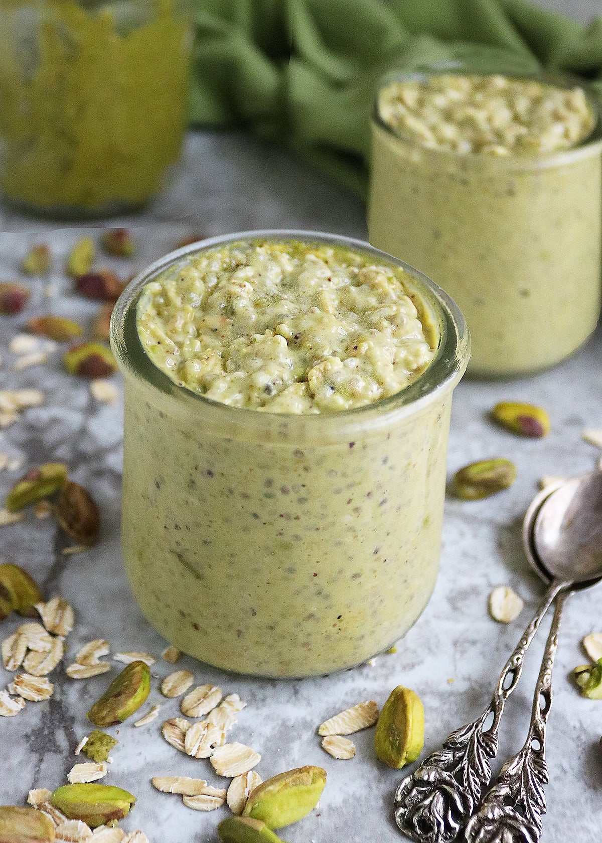 Easy pistachio overnight oats in 2 glass containers ready to be enjoyed.