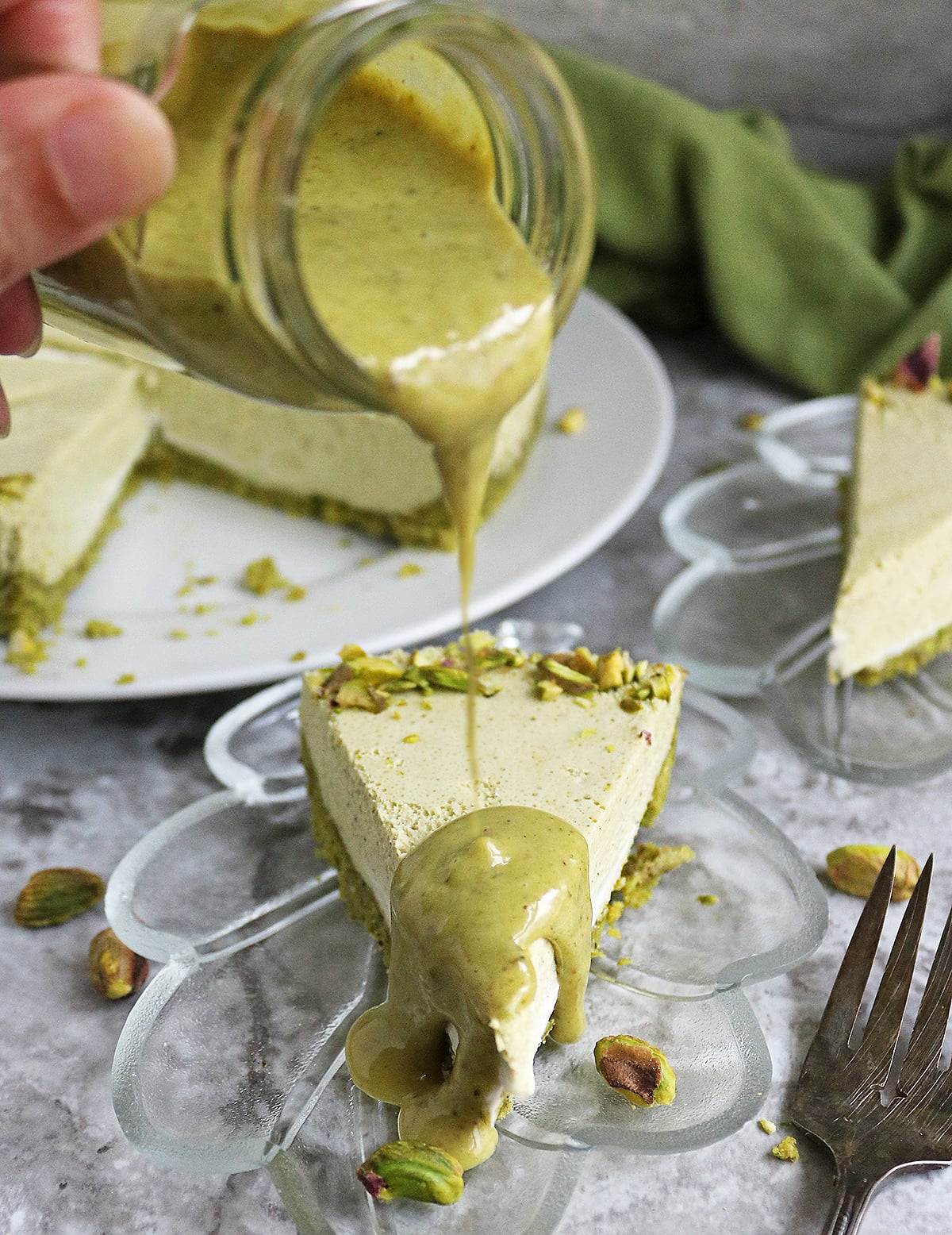 Adding a delicious pistachio topping onto this keto no bake pistachio cheesecake.