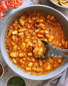 The best Easy 15 minute White Bean Marry Me Skillet in a large grey bowl with pink flowers close.