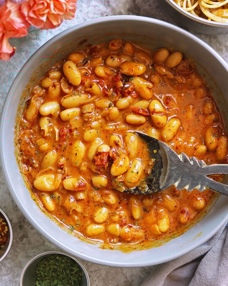 The best Easy 15 minute White Bean Marry Me Skillet in a large grey bowl with pink flowers close.