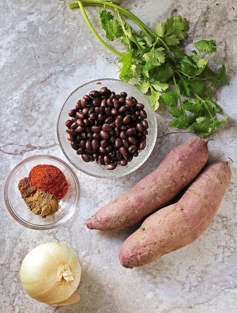 6 main ingredients and parsley to make a delicious purple sweet potato and black bean skillet