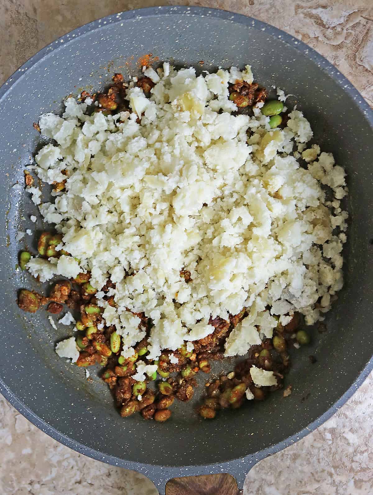 Adding mashed potato to the edamame saute