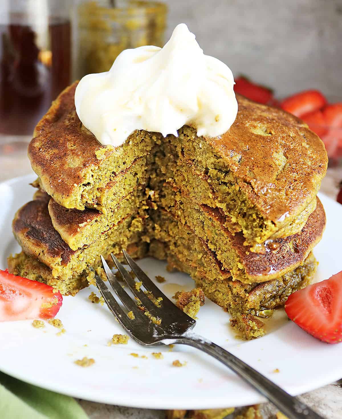 a bite out of a stack of low carb pistachio pancakes
