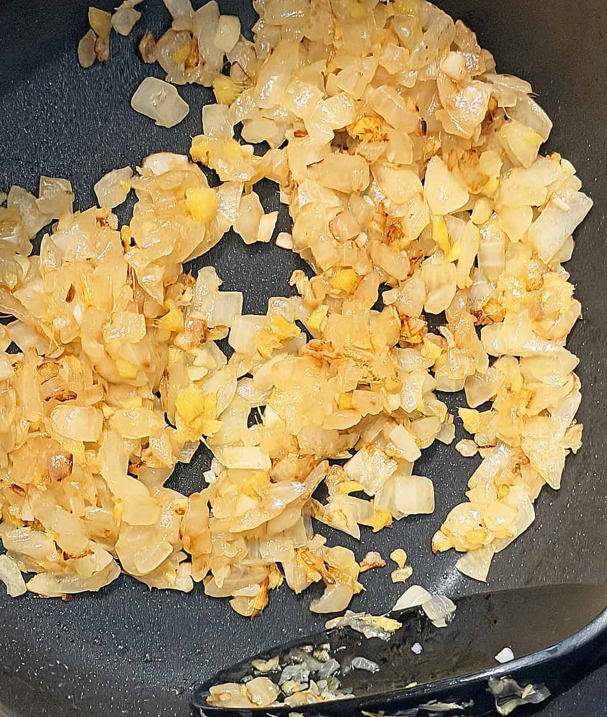 sauteeing the onion, ginger, and garlic until golden
