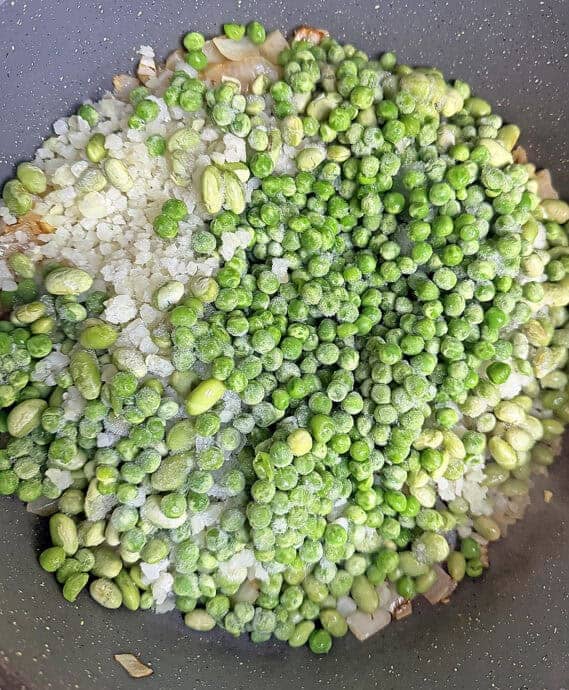 Adding frozen cauliflower, frozen peas, and frozen edamame