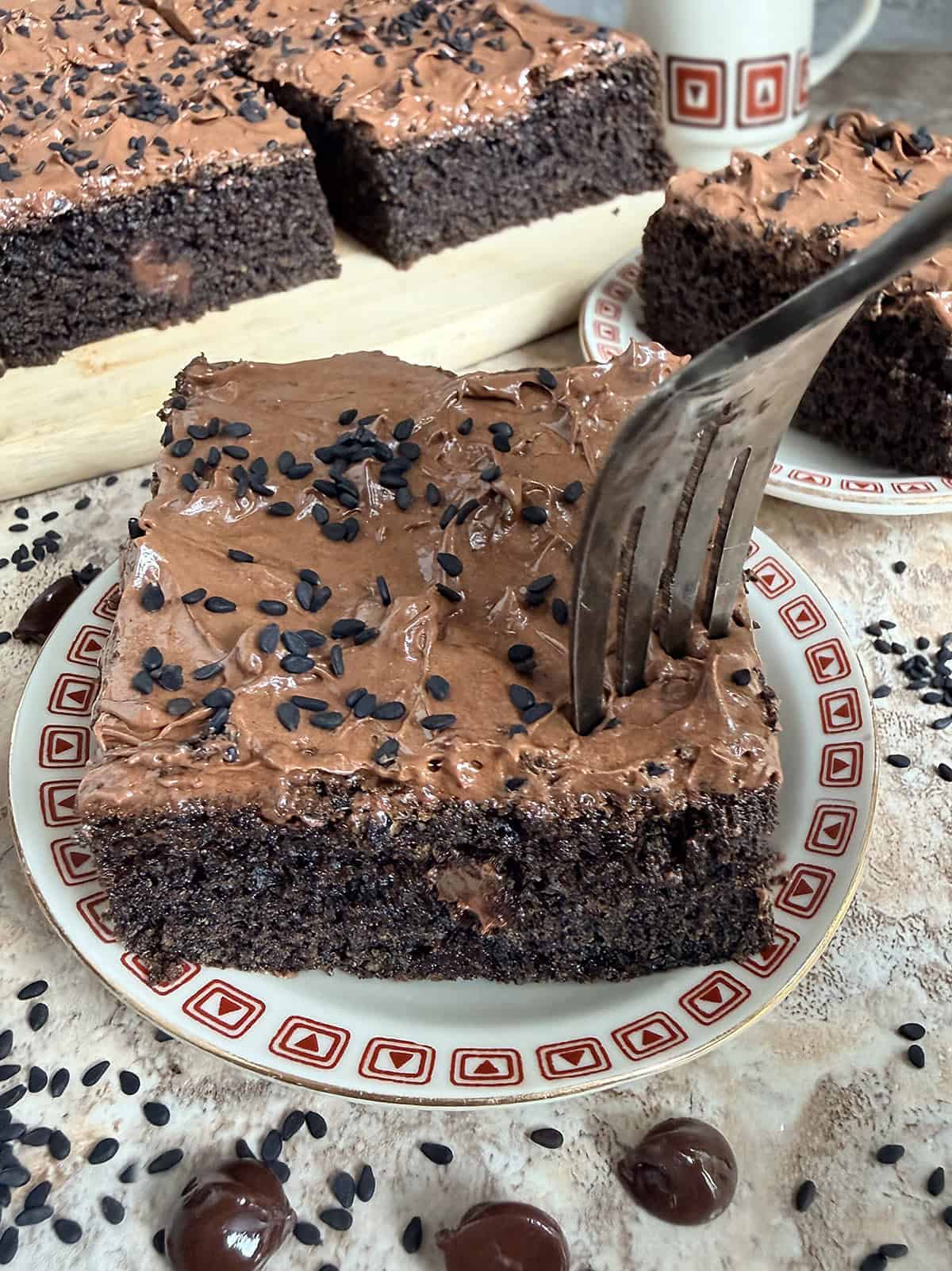 a slice of black sesame chocolate cake with a fork ready to dig into it.