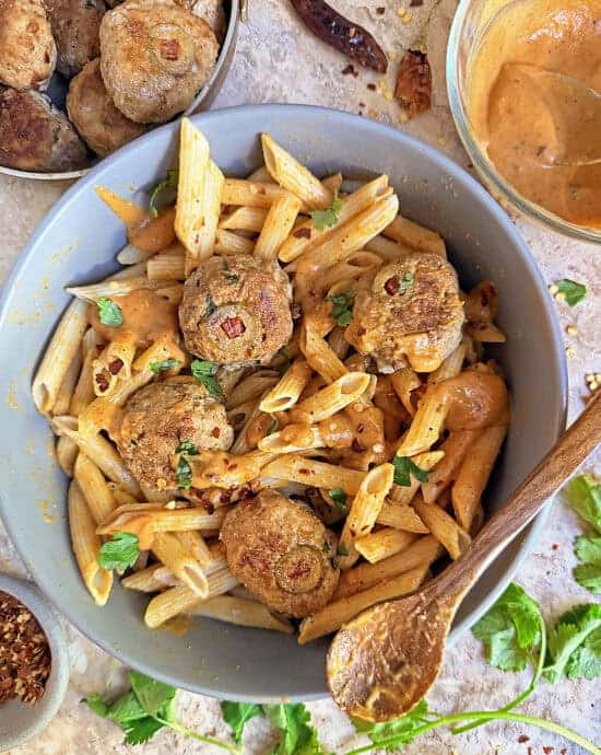 a large bowl with delicious pumpkin turkeyballs with pasta and harissa pumkin sauce.